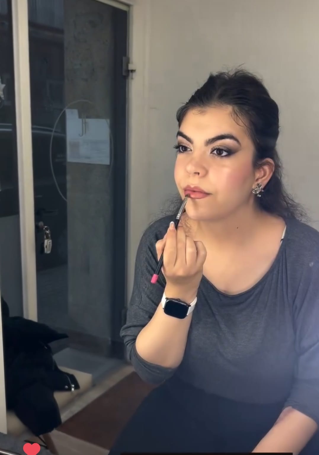 Clienta realizando curso de automaquillaje y aplicandose el labial, con un maquillaje natural y elegante en el estudio de maquillaje en Barcelona.