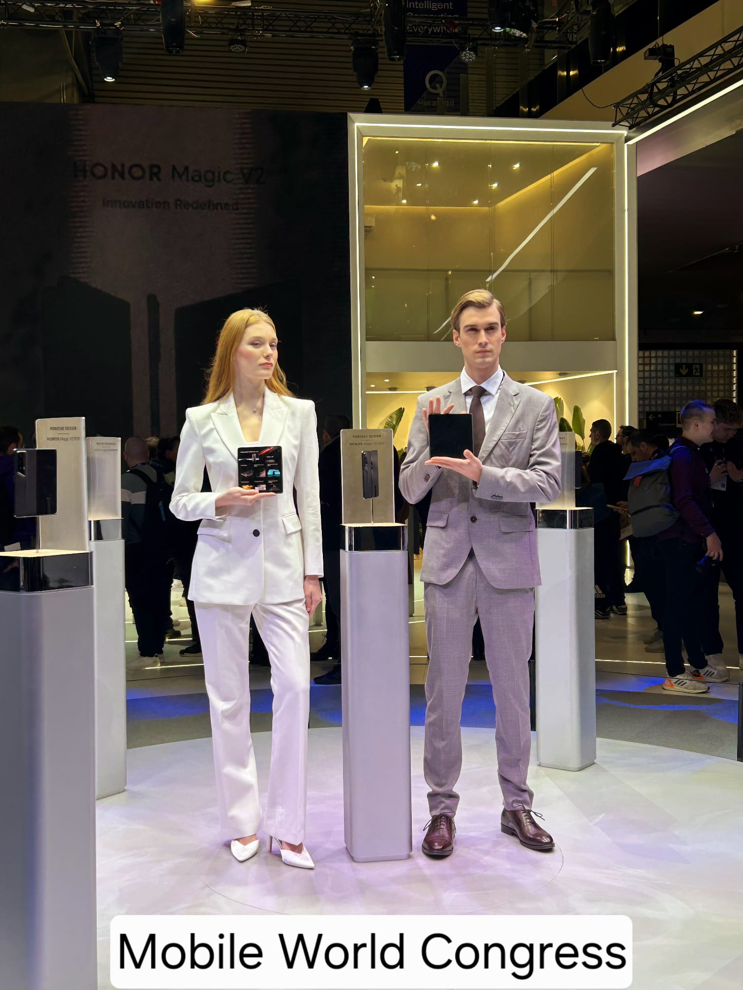 Presentación del HONOR Magic V2 en el stand de HONOR durante el Mobile World Congress, con dos modelos exhibiendo el smartphone plegable.