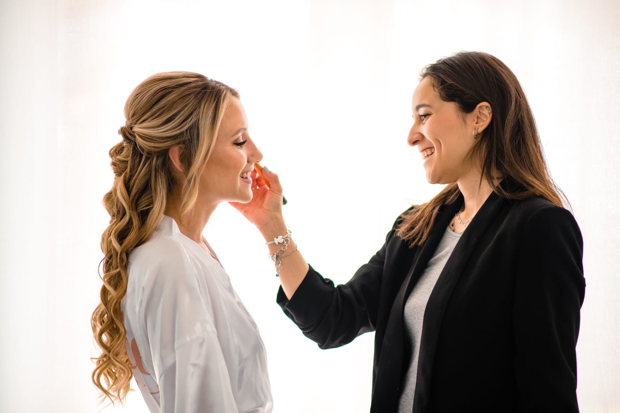 Maquilladora profesional aplicando maquillaje a novia durante preparación de boda en Barcelona