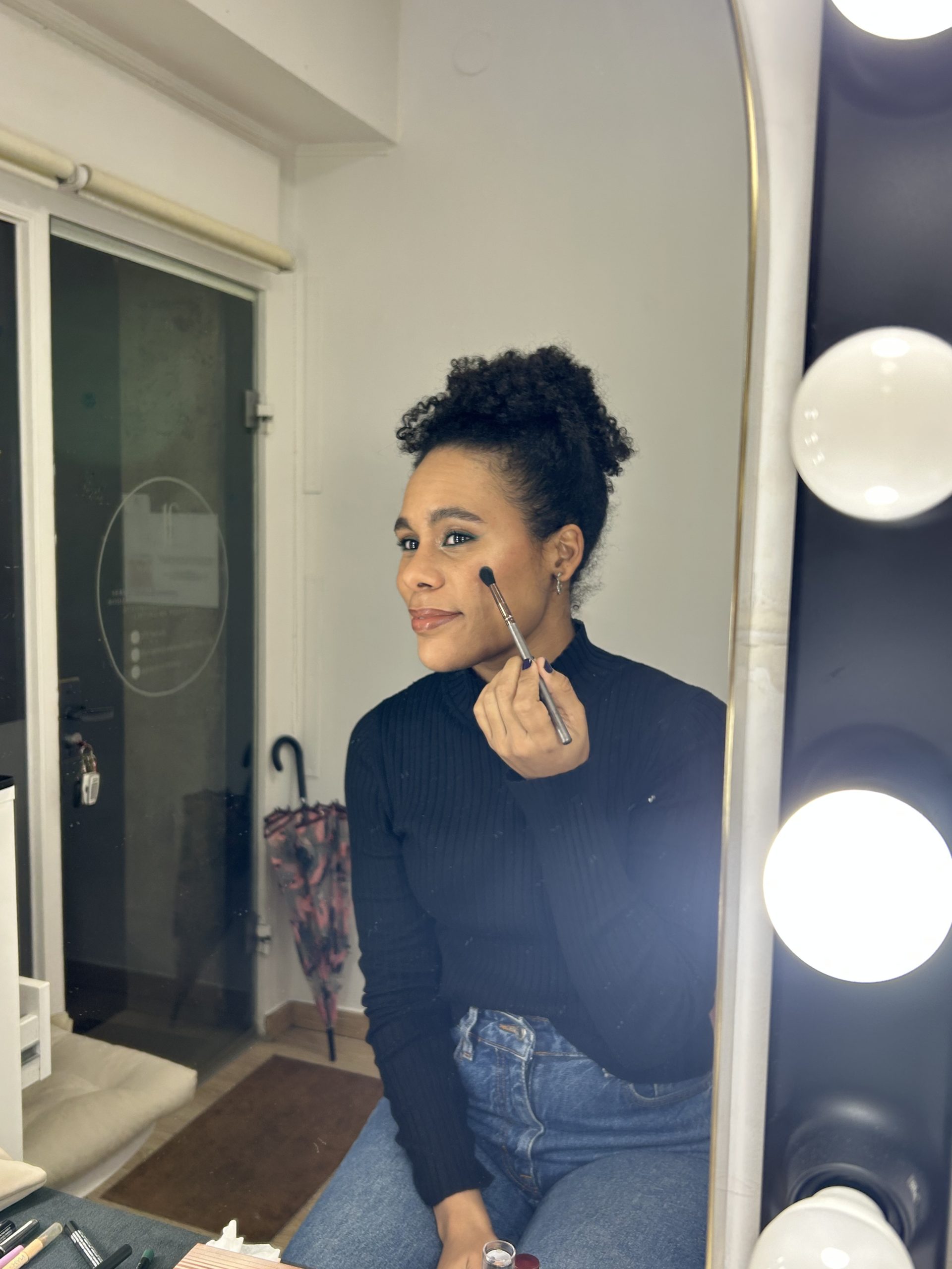 Mujer aprendiendo a maquillarse en curso de automaquillaje en Barcelona con maquilladora profesional aplicando base de maquillaje natura